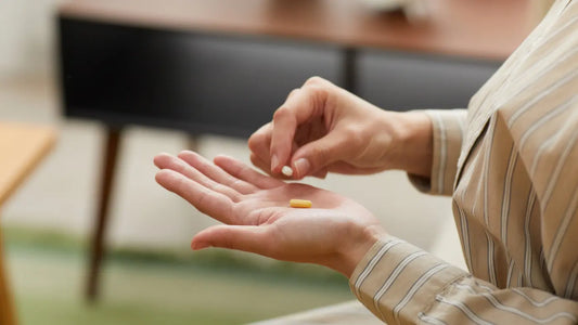 Frau mit gestreiftem Hemd hält zwei Tabletten in den Händen